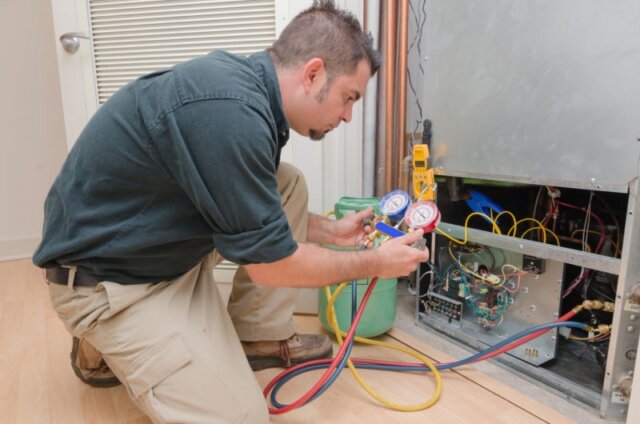 Técnico de HVAC carregando uma bomba de calor com refrigerante